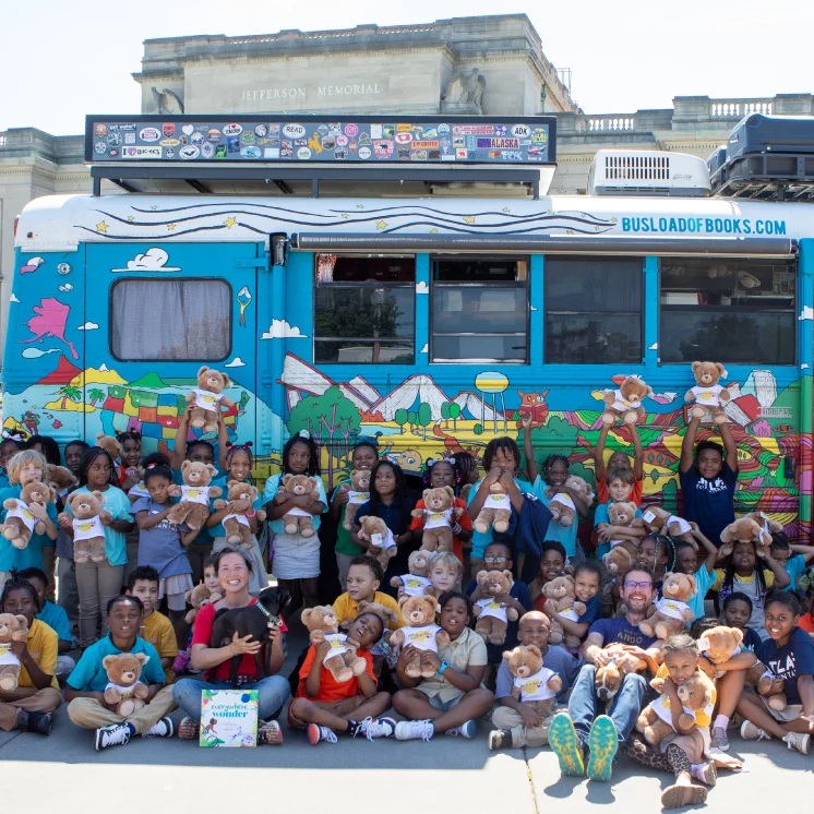 group of children in front of a bus