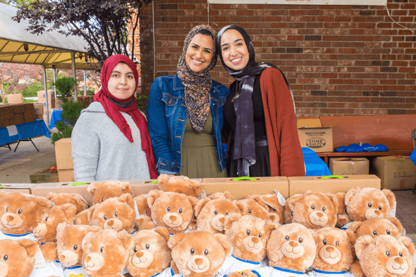 people standing by table of bears – Build-A-Bear Foundation