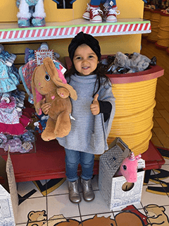 Child With Stuffed Bunny Giving Thumbs Up
