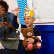Boy with party hat holding bear