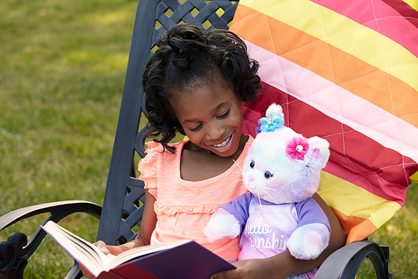child reading with plush cat – Build-A-Bear Foundation
